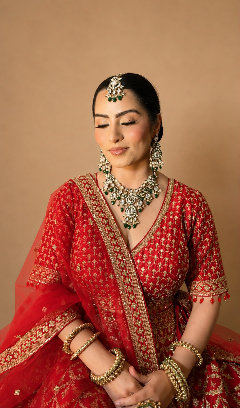 Red bridal with kundan and emerald jewellery